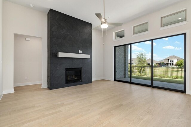 1417 Vermillion Dr, Prosper, TX 75078 - unfurnished living room with baseboards, a high ceiling, a ceiling fan, a fireplace, and wood finished floors