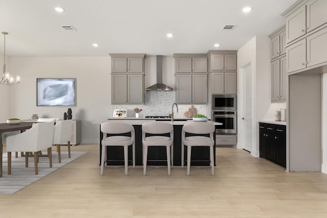 1417 Vermillion Dr, Prosper, TX 75078 - kitchen with gray cabinets, tasteful backsplash, wall chimney exhaust hood, stainless steel appliances, and visible vents