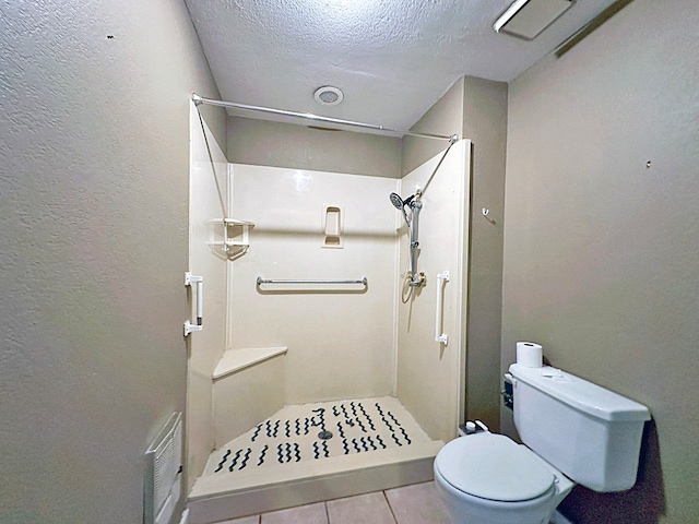 bathroom with a shower, tile patterned flooring, toilet, and a textured ceiling