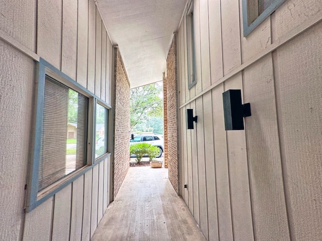 hallway with lofted ceiling and light hardwood / wood-style floors