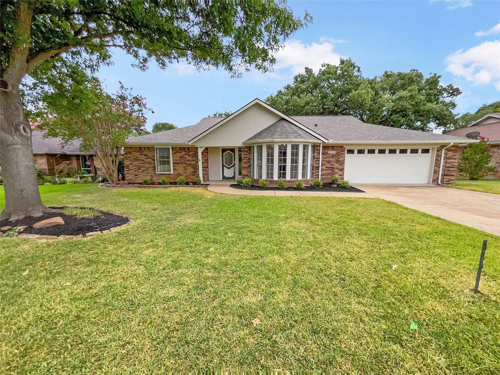 single story home featuring a garage and a front yard