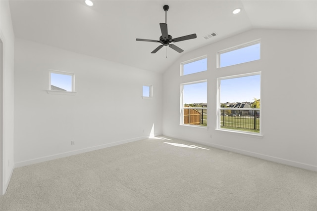 empty room with vaulted ceiling, light colored carpet, and ceiling fan