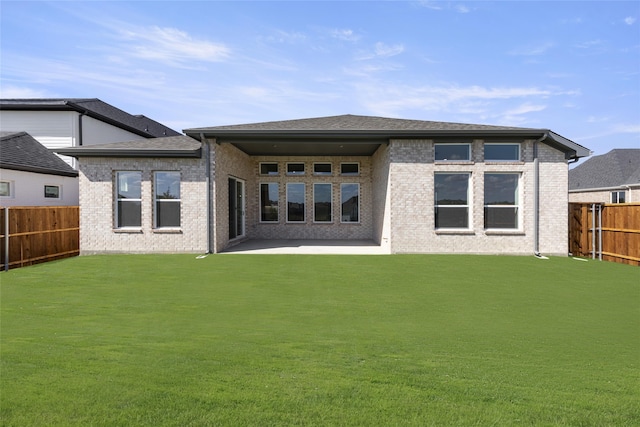 rear view of house with a yard and a patio area