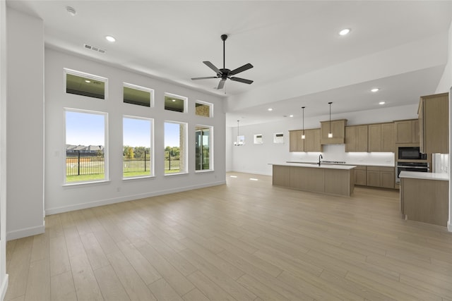 unfurnished living room featuring ceiling fan and light hardwood / wood-style flooring