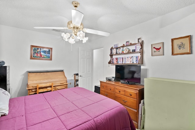 bedroom with ceiling fan and a textured ceiling