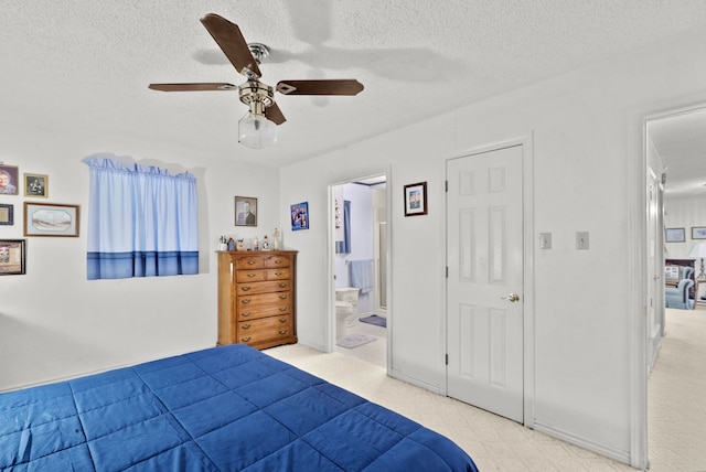 bedroom featuring ceiling fan, ensuite bath, and a textured ceiling