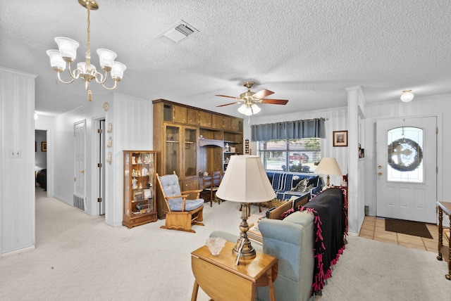 living room with ceiling fan with notable chandelier and a textured ceiling