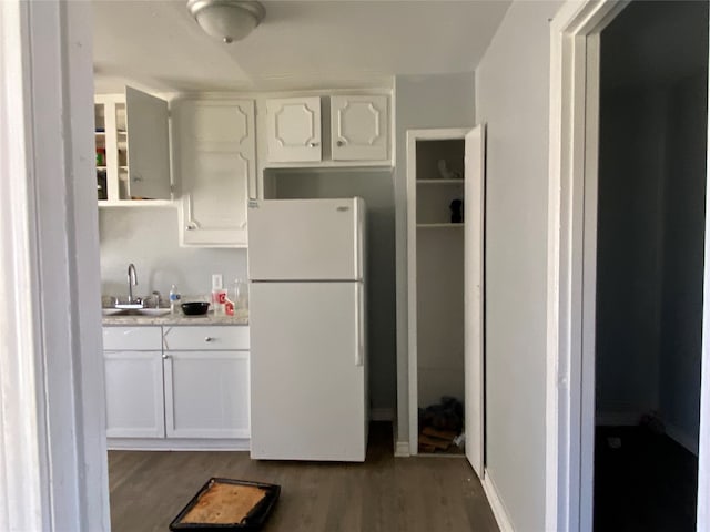 kitchen with sink, dark hardwood / wood-style flooring, white refrigerator, and white cabinetry