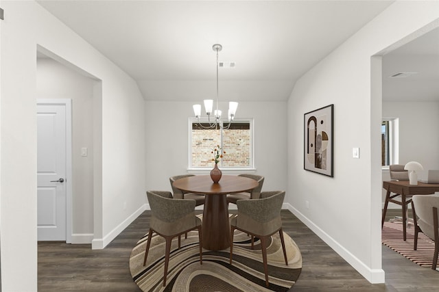 dining area with dark wood-type flooring, a chandelier, and vaulted ceiling