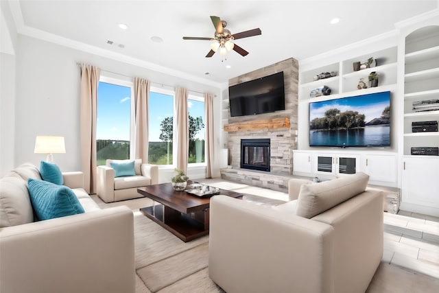 living room featuring ceiling fan, built in features, a stone fireplace, and ornamental molding