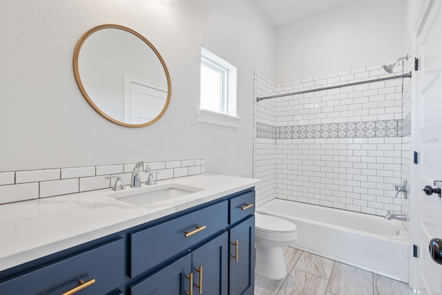 full bathroom with vanity, tiled shower / bath combo, and toilet