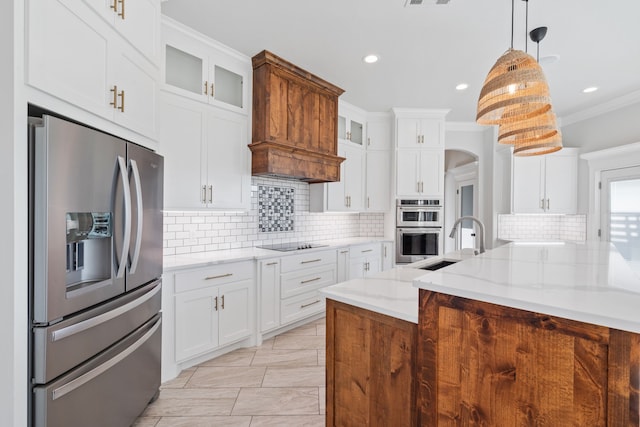 kitchen with light stone counters, decorative light fixtures, stainless steel appliances, and white cabinets