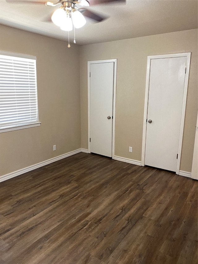 unfurnished bedroom with ceiling fan and dark hardwood / wood-style floors