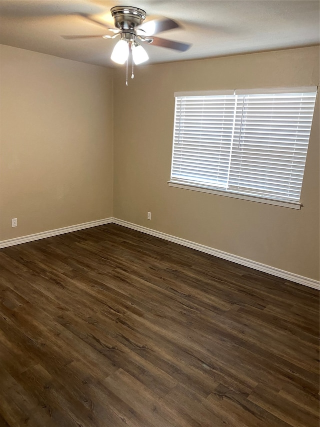 spare room with dark wood-type flooring and ceiling fan