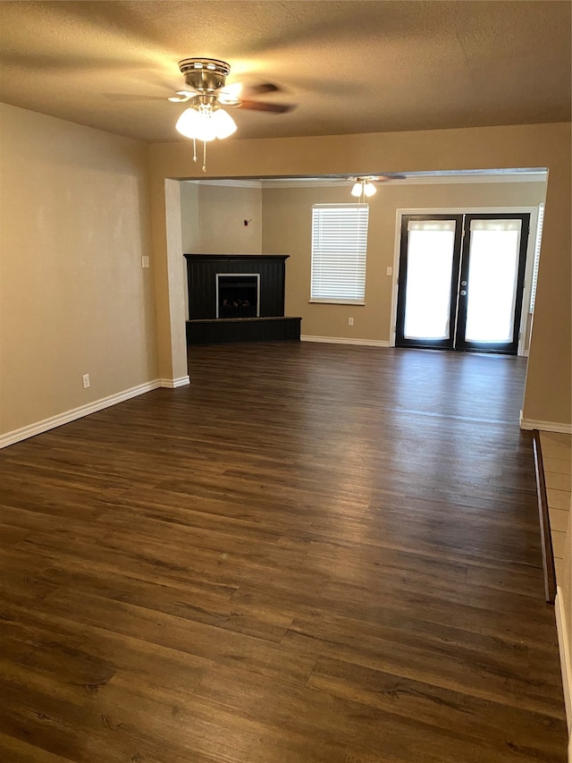 unfurnished living room featuring dark wood-type flooring, a textured ceiling, french doors, and ceiling fan