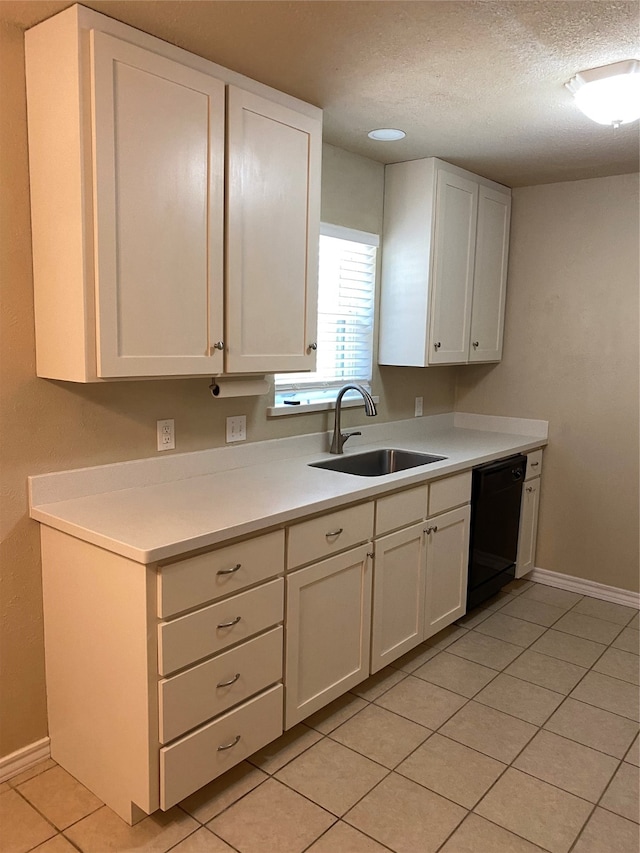 kitchen featuring white cabinetry, dishwasher, light tile patterned floors, and sink