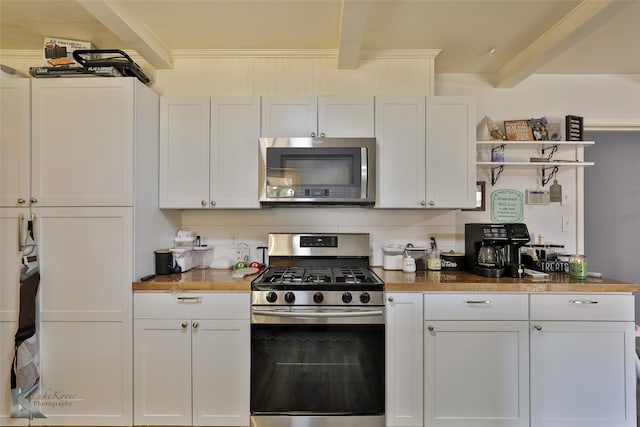 kitchen featuring stainless steel appliances, beam ceiling, white cabinetry, crown molding, and wooden counters