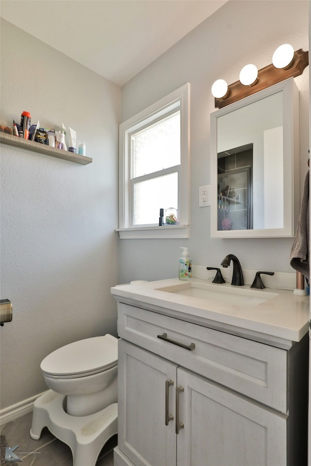 bathroom with tile patterned flooring, vanity, and toilet