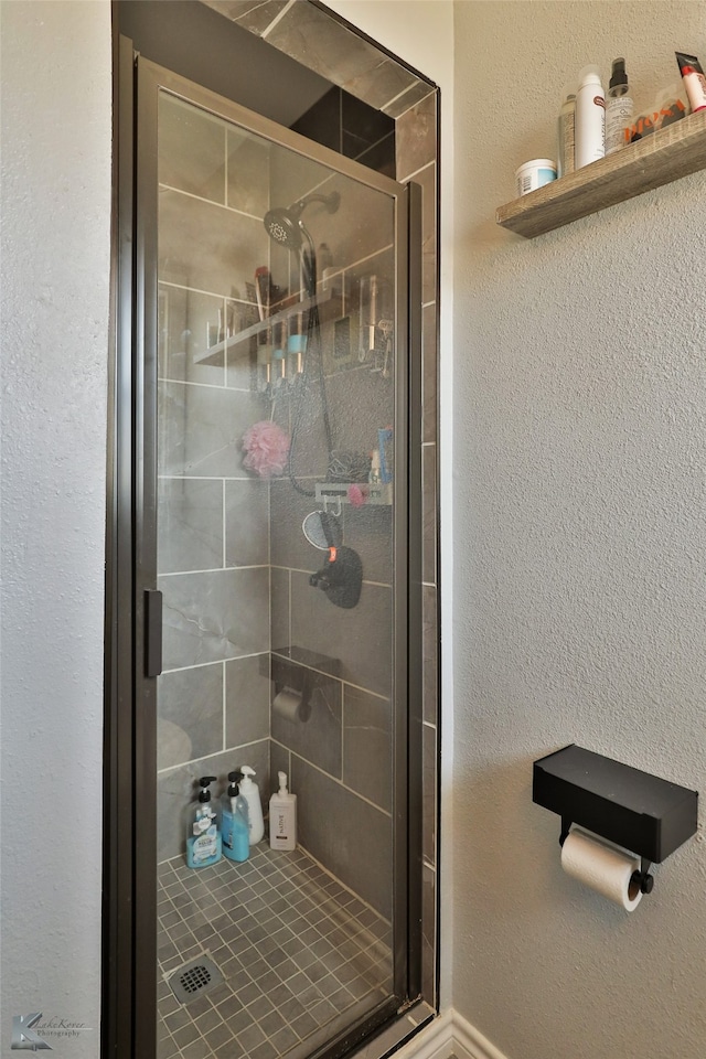 bathroom with a shower with door