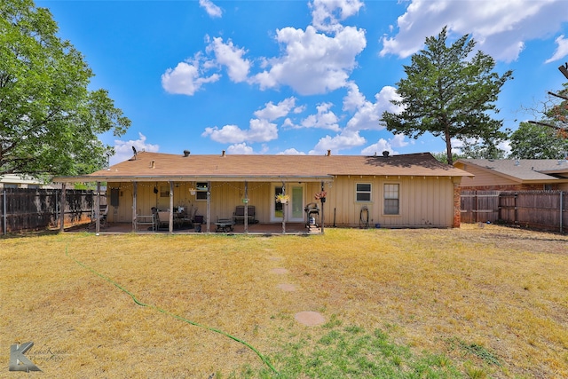 back of property featuring a patio area and a yard