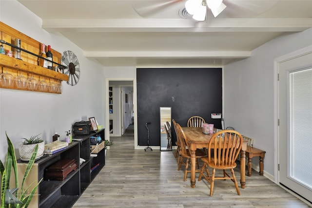 dining area featuring ceiling fan, beamed ceiling, and hardwood / wood-style floors