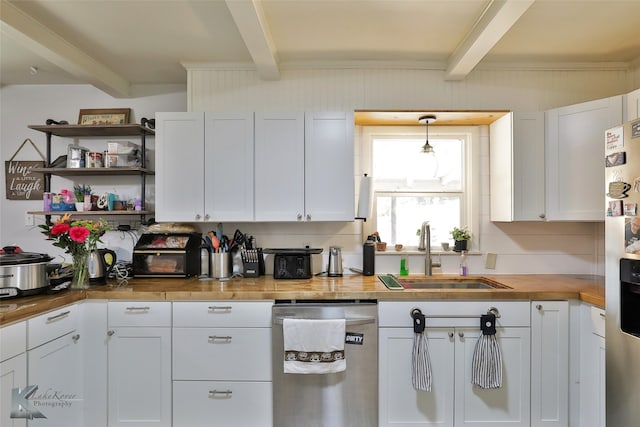 kitchen with beamed ceiling, appliances with stainless steel finishes, sink, and white cabinets