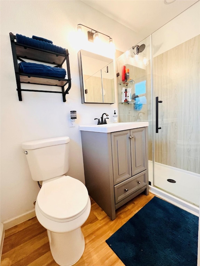 bathroom featuring walk in shower, wood-type flooring, toilet, and vanity