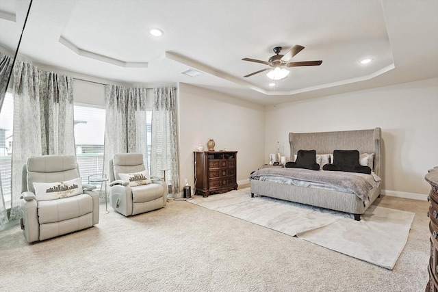 bedroom with light carpet, a raised ceiling, and ceiling fan