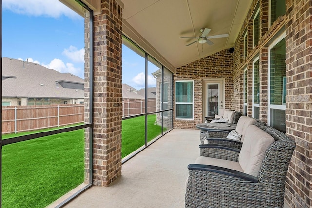 unfurnished sunroom with vaulted ceiling and ceiling fan