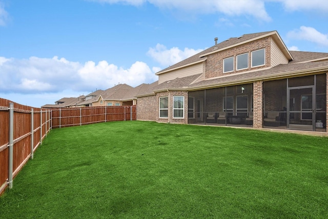 back of property with a sunroom and a yard