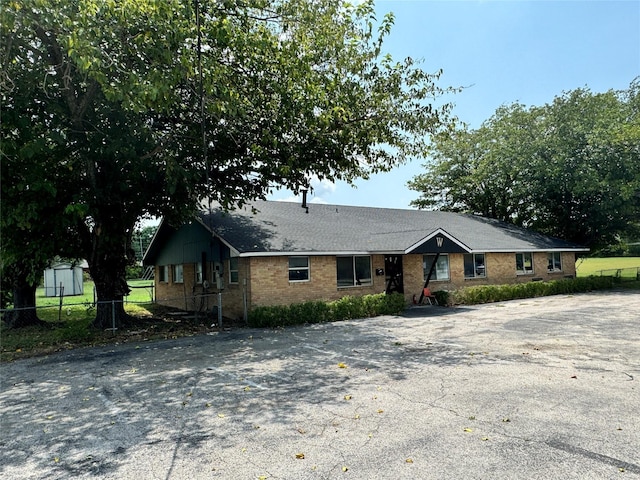 view of front facade featuring brick siding and fence