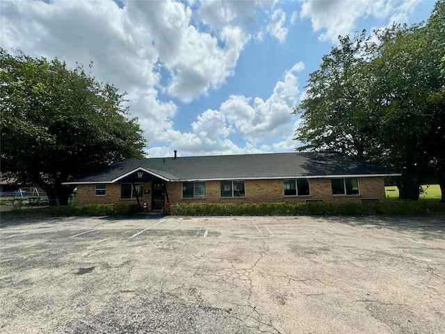 ranch-style house with uncovered parking and brick siding