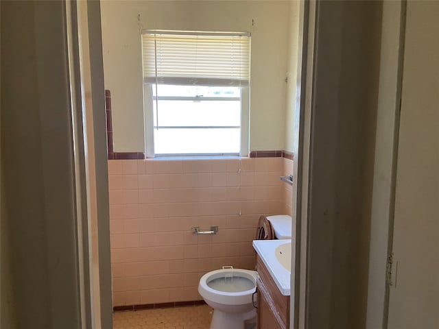 bathroom with vanity, tile patterned flooring, toilet, and tile walls