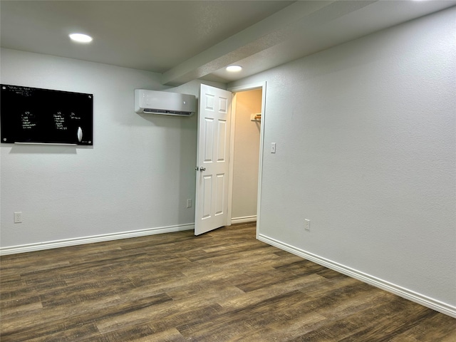 unfurnished room featuring a wall mounted AC and dark wood-type flooring