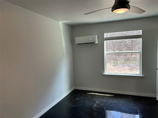 empty room with a wall mounted air conditioner, a textured ceiling, and ceiling fan