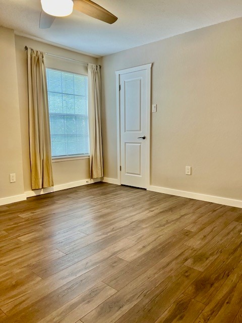 unfurnished room with wood-type flooring and ceiling fan