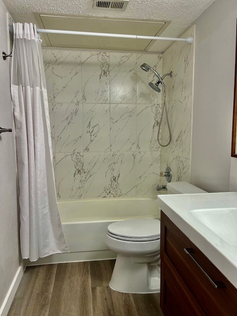 full bathroom with shower / bathtub combination with curtain, a textured ceiling, toilet, vanity, and hardwood / wood-style floors