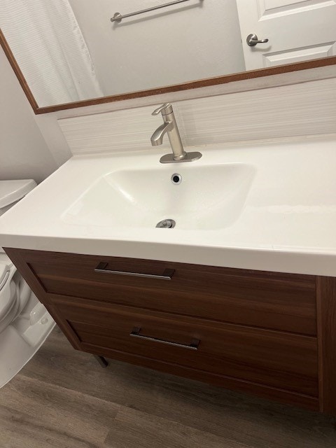 bathroom featuring toilet, hardwood / wood-style floors, and vanity