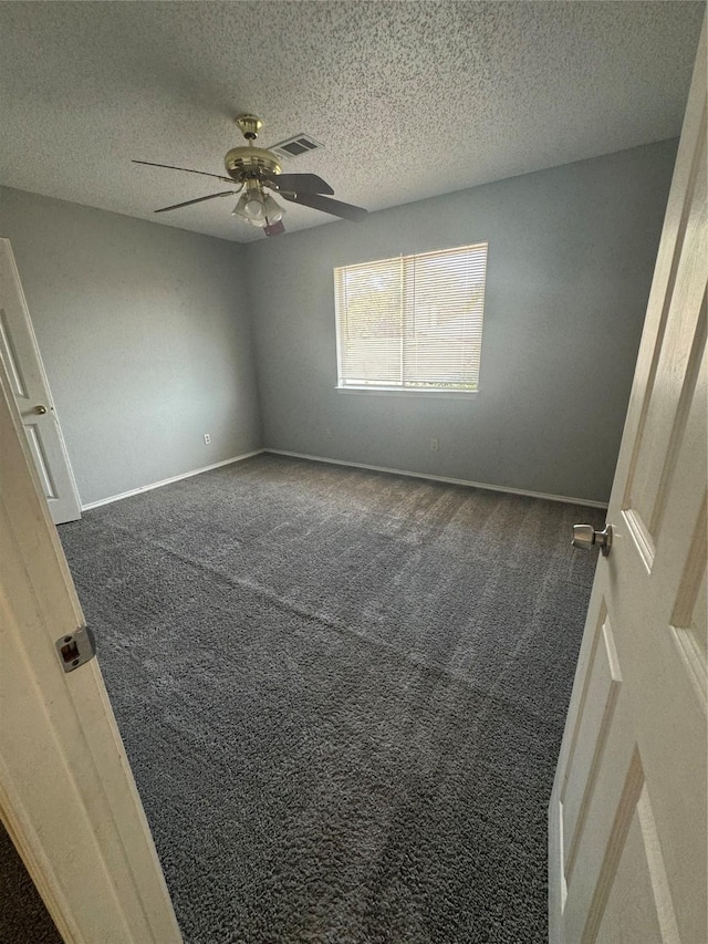 carpeted empty room with ceiling fan and a textured ceiling