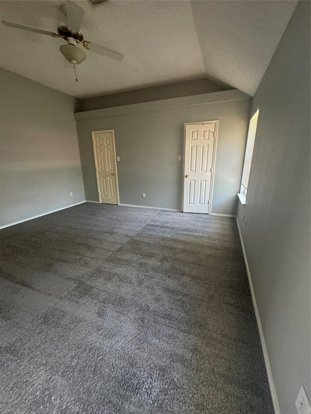 carpeted spare room with ceiling fan and lofted ceiling