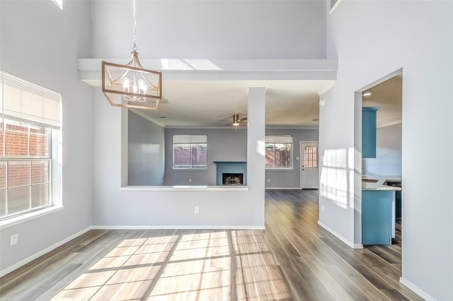 unfurnished living room featuring hardwood / wood-style flooring, a wealth of natural light, and ornamental molding