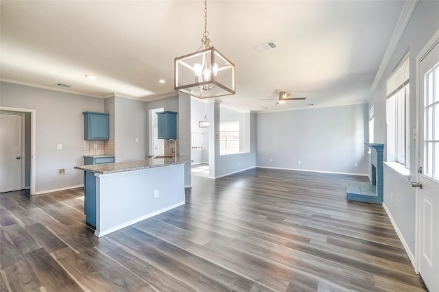 kitchen with blue cabinetry, dark wood-type flooring, and ceiling fan with notable chandelier