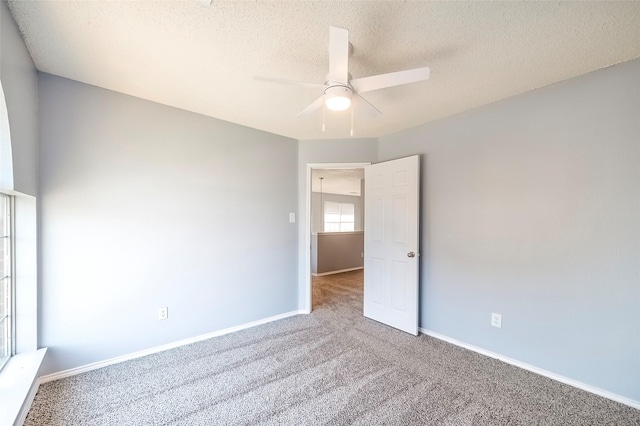 carpeted spare room with ceiling fan and a textured ceiling