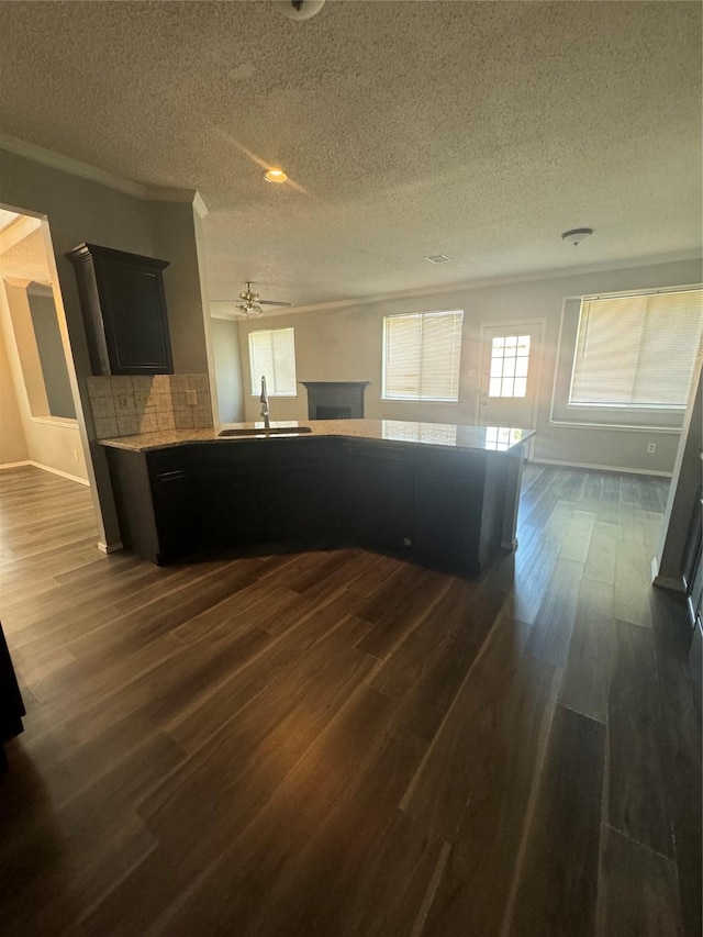 kitchen featuring a textured ceiling, dark hardwood / wood-style floors, sink, and tasteful backsplash