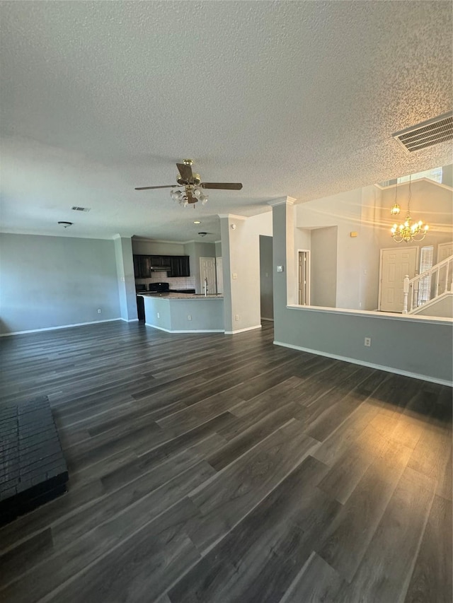 unfurnished living room featuring dark hardwood / wood-style flooring, ceiling fan with notable chandelier, and a textured ceiling