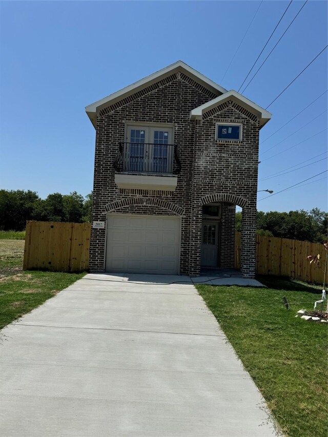 front of property featuring a balcony, a garage, and a front yard