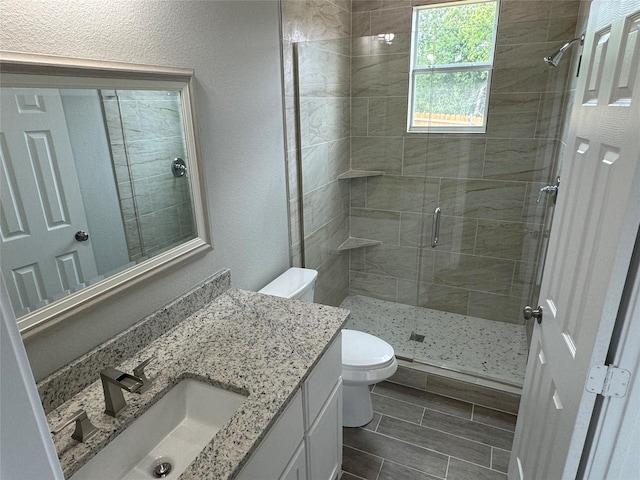 bathroom featuring walk in shower, vanity, and toilet