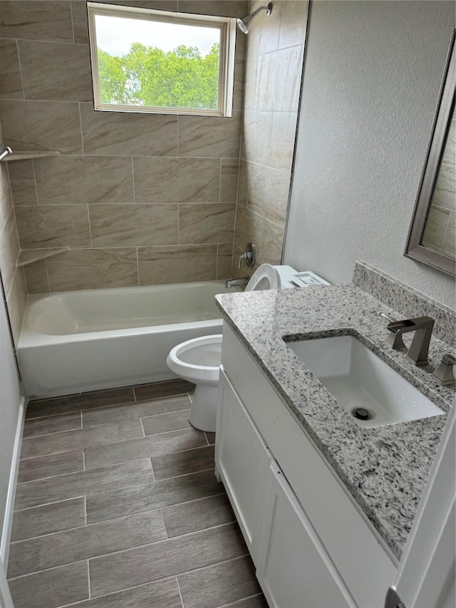 full bathroom featuring tiled shower / bath combo, vanity, and toilet