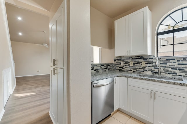 kitchen with white cabinetry, light hardwood / wood-style flooring, light stone counters, stainless steel dishwasher, and sink