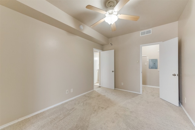 empty room with electric panel, light colored carpet, and ceiling fan